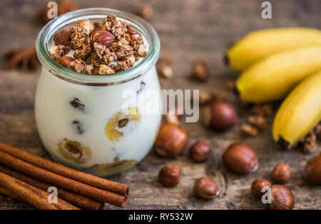 Mit Joghurt mit Müsli, Bananen und Nüsse Stockfoto