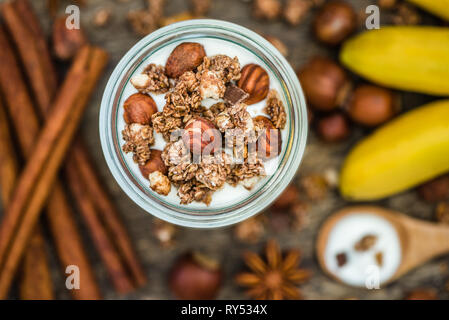 Mit Joghurt mit Müsli, Bananen und Nüsse Stockfoto