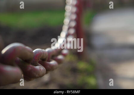 Close-up Alte Metall Kette auf Zaun Hintergrund im Sonnenlicht. Stockfoto