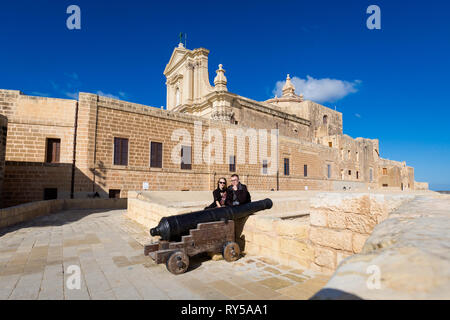 Junges Paar und Kanone auf Citadella Schloss in Victoria, Hauptstadt der Insel Gozo. Historische Architektur von Malta. Stockfoto