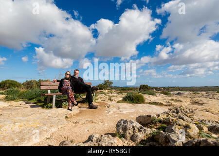 Junges Paar sitzt auf der Bank hohe Dingli Cliffs auf Malta Insel. Schöne Landschaft im Süden von Europa. Stockfoto