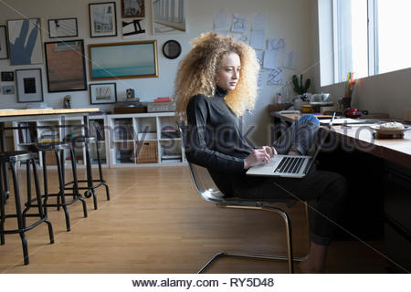 Junge Frau mit Laptop im Studio