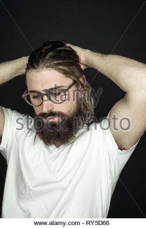 Junge schöne hipster Mann mit Bart und Hände im Kopf