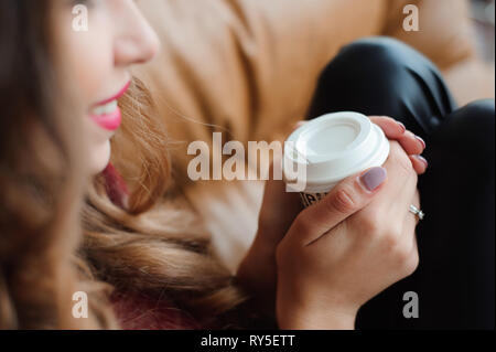 Attraktive Geschäftsfrau haben eine Kaffeepause in der Nähe der Fenster Stockfoto