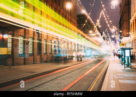 Helsinki, Finnland. Die Straßenbahn fährt In Motion Blur von Stop auf Aleksanterinkatu Straße in Kluuvi erhalten Bezirk in Abend Nacht Weihnachten Neujahr Stockfoto