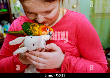 Papagei Vogel auf junge Mädchen Hand lächelnd das Spielen mit Ihrem Vogel Haustier. Stockfoto