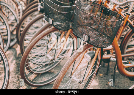 In der Nähe von Rad der Fahrräder auf dem Parkplatz in der Stadt. Sonnenlicht Sonnenschein durch die Speichen des Rades. Stockfoto