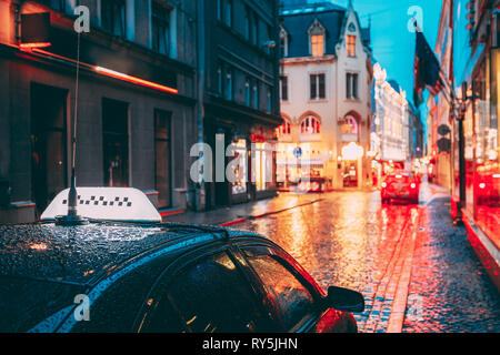 Taxi Auto warten Kunden In alten europäischen Straßen In den regnerischen Abend. Night Street Illuminations Stockfoto