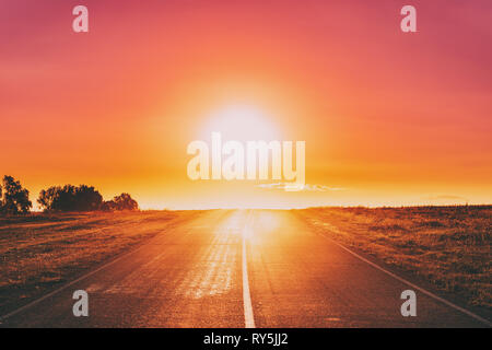 Asphalt Land Open Road im sonnigen Morgens oder abends. Open Road in der Sommersaison bei Sunny Sonnenuntergang bzw. Sonnenaufgang Stockfoto