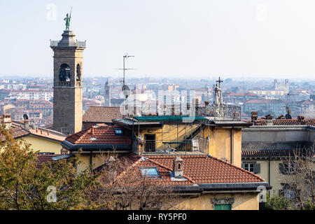 Reisen nach Italien - oben Blick auf den Glockenturm der Kirche Chiesa di Sant Alessandro della Croce über städtische Häuser der Stadt Bergamo. Stockfoto