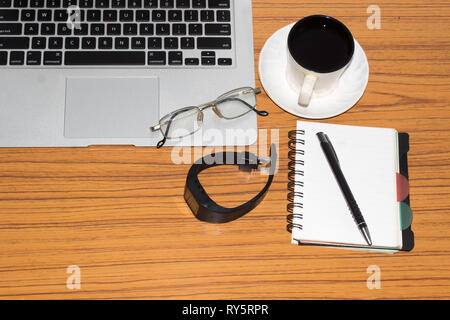 Schreibtisch mit offenen Notebook, Armbanduhren, Brillen, Kugelschreiber und einer Tasse Kaffee. Ansicht von oben mit der Kopie. Business still life Konzept mit Office Material auf Stockfoto