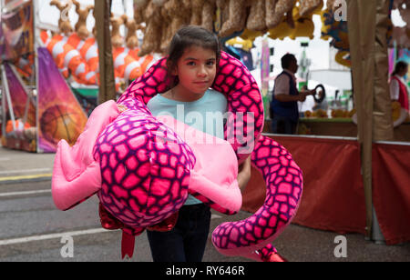 (190312) - HOUSTON, 12. März 2019 (Xinhua) - ein Mädchen trägt ihr Preisgeld von Toy Schlange beim Karneval während der Houston Livestock Show und Rodeo in Houston, Texas, USA, am 11. März 2019. Viele Eltern mit ihren Kindern zu der Veranstaltung am Montag, dem ersten Tag der Spring Break. Die jährlichen Houston Livestock Show und Rodeo,, die am 25. Februar dieses Jahres trat, wird bis 17. März statt. (Xinhua / Yi-Chin Lee) Stockfoto