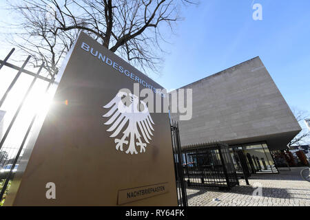 Karlsruhe, Deutschland. 12 Mär, 2019. Äußere Aufnahme der Bundesgerichtshof (BGH) mit ein Schild mit einem Bundesadler und der Schriftzug Bundesgerichtshof. Der BGH verhandelt über die Haftung für Life Support durch künstliche Ernährung. Die Klage wurde von einem Mann, der glaubt, dass sein Vater, der an Demenz leidet, unnötig lange am Leben gehalten wurde. Als Erbe, er verlangt Schmerzensgeld und Ersatz für Behandlung und Pflege Kosten aus den behandelnden Hausarzt, in Höhe von insgesamt mehr als 150.000 Euro. Credit: Uli Deck / dpa/Alamy leben Nachrichten Stockfoto