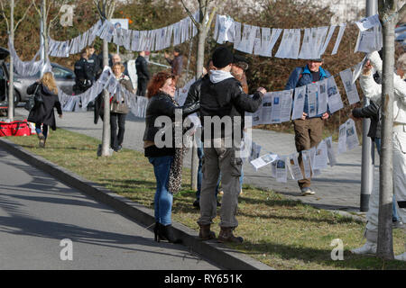 Wiesbaden, Deutschland. 12. März 2019. Aktivisten auflegen, die Leine des Grauens' (Leine des Schreckens), eine Linie mit der gedruckten Zeitung Berichte über angebliche Verbrechen der Flüchtlinge. Die Gerichtsverfahren gegen die irakische Asylbewerber Ali B. für den Mord an Susanna F. aus Mainz war letztes Jahr in Wiesbaden eröffnet. Mehrere rechtsradikale Organisationen ein Protest außerhalb des Court House gegen Flüchtlinge in Deutschland und für härtere Strafen für Flüchtlinge. Quelle: Michael Debets/Alamy leben Nachrichten Stockfoto