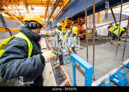 11. März 2019, Baden-Wuerttemberg, Mühlhausen im Täle: Arbeiter gießen Beton in die Schalung auf der Baustelle des Filstal Brücke auf dem Aichelberg. Die Brücke ist Teil der neuen Wendlingen-Ulm Abschnitt des Stuttgart 21 Bahn Projekt. Sobald die Einstellung abgeschlossen ist, wird es sein, rund 800 Meter lang und 50 Meter hoch. Foto: Fabian Sommer/dpa Stockfoto