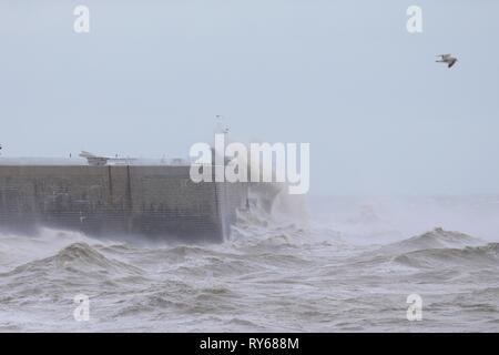 Folkestone, Kent, Großbritannien. 12 Mär, 2019. UK Wetter: Sturm Gareth kommt an der Südküste mit Böen Schlagen über 55 mph. Der Hafen von Folkestone arm und Leuchtturm wird gerade Renovierungsarbeiten nimmt die volle Kraft des Sturms. © Paul Lawrenson 2019, Foto: Paul Lawrenson/Alamy leben Nachrichten Stockfoto