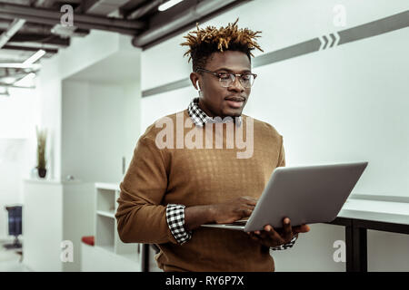 Afrikanische amerikanische Programmierer in klare Gläser holding Laptop Stockfoto