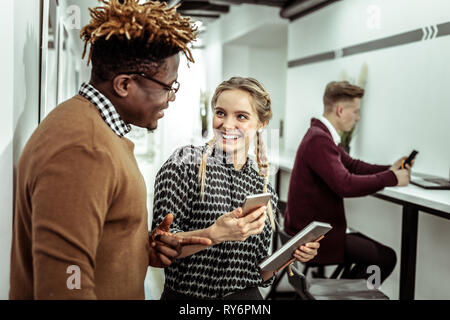 Zufrieden lächelnd Dame mit ihrem schwarzen Kollegin flirten Stockfoto