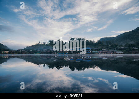 Häuser auf ruhigen See gegen Himmel widerspiegelt Stockfoto