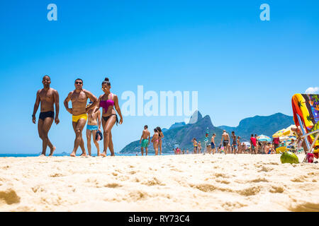 Rio De Janeiro Februar 10 2017 Junge Brasilianische Manner Tragen Einen Stil Der Bademode Lokal Bekannt Als Unga Zu Fuss Mit Einer Frau Im Bikini In Ipanema Stockfotografie Alamy