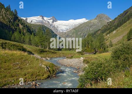 Gletscherbach, Gschlößbach im Tauern Tal, hinter es schwarze Wand, hohen Zaun und Großvenediger Stockfoto