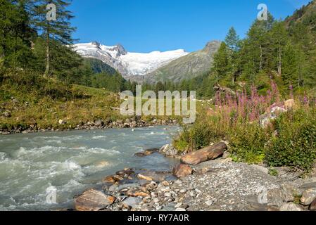 Gletscherbach, Gschlößbach im Tauern Tal, hinter es schwarze Wand, hohen Zaun und Großvenediger Stockfoto