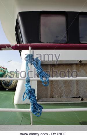 Zwei farbenfrohe blaue Seile hängen von der Seite eines Fischtrawler in Dingle Bay auf einem blustry Tag im März entlang der wilden Atlantikküste. Stockfoto