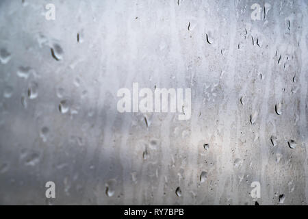 Сoncept der Umweltbelastungen in der Industriestadt. Schmutziger Regentropfen auf dem Glas, Nahaufnahme. Stockfoto