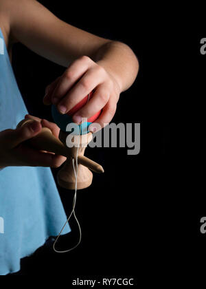 Klassische japanische Spiel Kendama, junge Hände spielen mit Holz Farbe Kendama Stockfoto