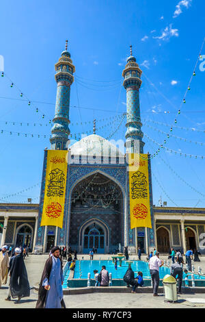 Qom Azam Moschee Seitenansicht mit Quran Inschriften auf gelben Vorhang und Fuß schwarz Turban Imam Stockfoto