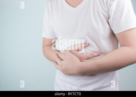 Asiatische junge Männer leiden unter Magengeschwüren. Gastritis durch die Infektion mit H. pylori-Bakterien im Gesundheitswesen und Gesundheit Problem Konzept verursacht Stockfoto