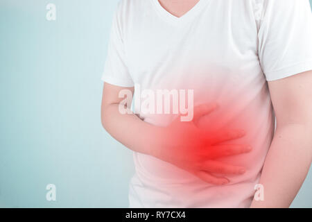 Asiatische junge Männer leiden unter Magengeschwüren. Gastritis durch die Infektion mit H. pylori-Bakterien im Gesundheitswesen und Gesundheit Problem Konzept verursacht Stockfoto