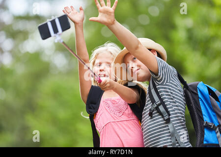 Zwei Kinder auf eine Wanderung nehmen selfie mit Smartphone auf selfie Stick Stockfoto
