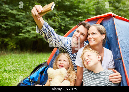 Glückliche Familie mit zwei Kindern ist ein selfie beim Camping im Sommer Stockfoto