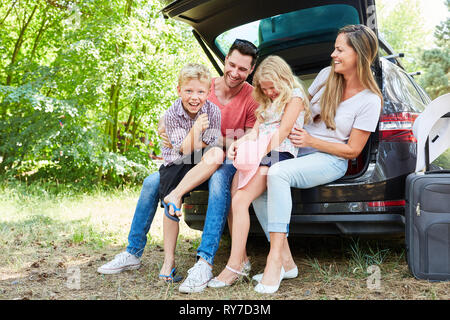 Eltern und Kinder gemeinsam Lachen im Auto vor den Sommerferien Stockfoto