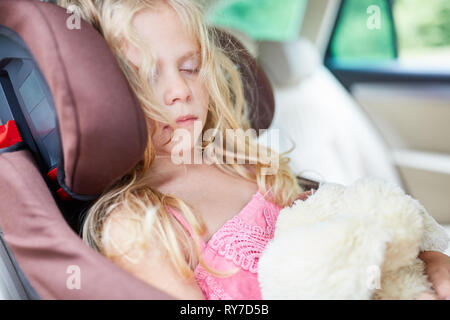 Schlafende Mädchen auf dem Rücksitz im Kindersitz im Auto auf der Fahrt Stockfoto