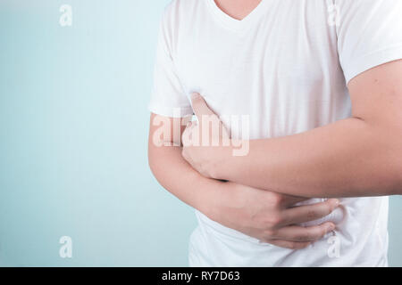 Asiatische junge Männer leiden unter Magengeschwüren. Gastritis durch die Infektion mit H. pylori-Bakterien im Gesundheitswesen und Gesundheit Problem Konzept verursacht Stockfoto