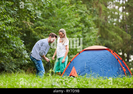 Junges Paar zusammen ein Zelt in der Natur auf dem Campingplatz Ferienhäuser bauen Stockfoto