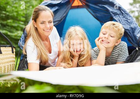 Mutter und zwei Kinder Camping vor der Hütte Blick auf die Landkarte Stockfoto