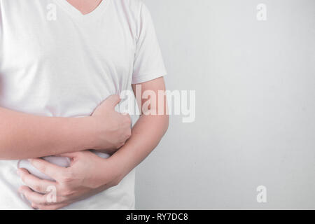 Asiatische junge Männer leiden unter Magengeschwüren. Gastritis durch die Infektion mit H. pylori-Bakterien im Gesundheitswesen und Gesundheit Problem Konzept verursacht Stockfoto