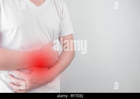 Asiatische junge Männer leiden unter Magengeschwüren. Gastritis durch die Infektion mit H. pylori-Bakterien im Gesundheitswesen und Gesundheit Problem Konzept verursacht Stockfoto