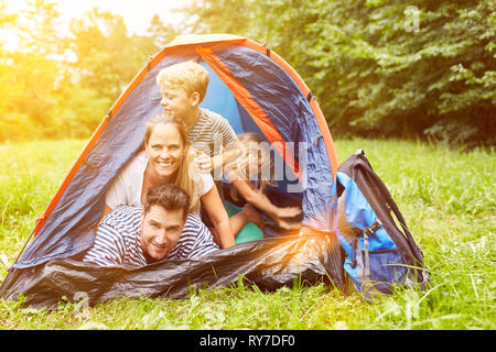 Glückliche Familie mit Kindern im Zelt beim Camping am Campingplatz im Sommer Stockfoto