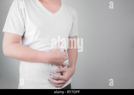 Asiatische junge Männer leiden unter Magengeschwüren. Gastritis durch die Infektion mit H. pylori-Bakterien im Gesundheitswesen und Gesundheit Problem Konzept verursacht Stockfoto