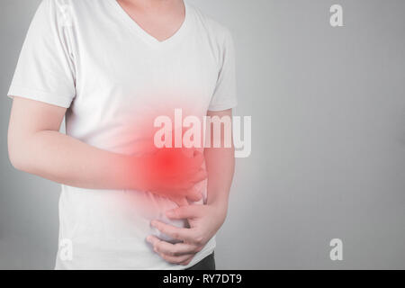 Asiatische junge Männer leiden unter Magengeschwüren. Gastritis durch die Infektion mit H. pylori-Bakterien im Gesundheitswesen und Gesundheit Problem Konzept verursacht Stockfoto