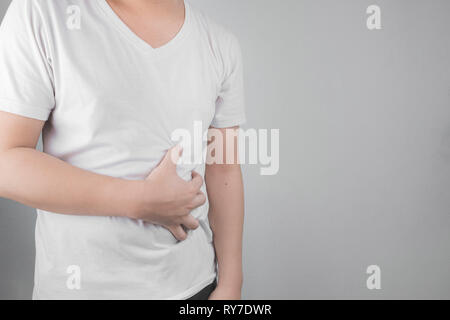 Asiatische junge Männer leiden unter Magengeschwüren. Gastritis durch die Infektion mit H. pylori-Bakterien im Gesundheitswesen und Gesundheit Problem Konzept verursacht Stockfoto