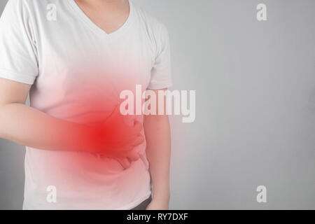 Asiatische junge Männer leiden unter Magengeschwüren. Gastritis durch die Infektion mit H. pylori-Bakterien im Gesundheitswesen und Gesundheit Problem Konzept verursacht Stockfoto