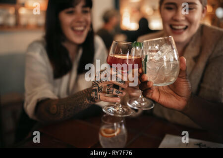 Lächelnd Freunde zusammen Toasten mit Getränken in der Bar Stockfoto