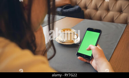 Frau mit Mobiltelefon mit Touchscreen im Cafe Stockfoto