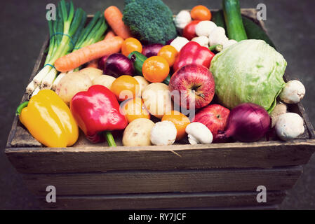 Vintage-Kiste gefüllt mit gemischten Früchten und Gemüse mit Retro-vsco-Filter. Veganismus. Veganuary. Vegane Küche. Gesunde Ernährung. Werkbasiert Stockfoto