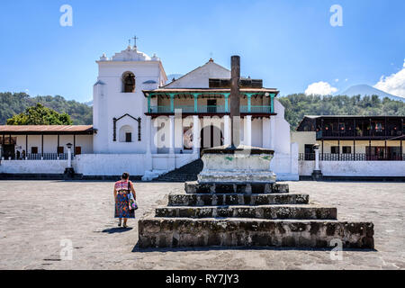 Santiago Atitlan See, Lake Atitlan, Guatemala - 8. März 2019: Maya Frau geht über Plaza auf die katholische Kirche in der Stadt am See im guatemaltekischen Hochland. Stockfoto